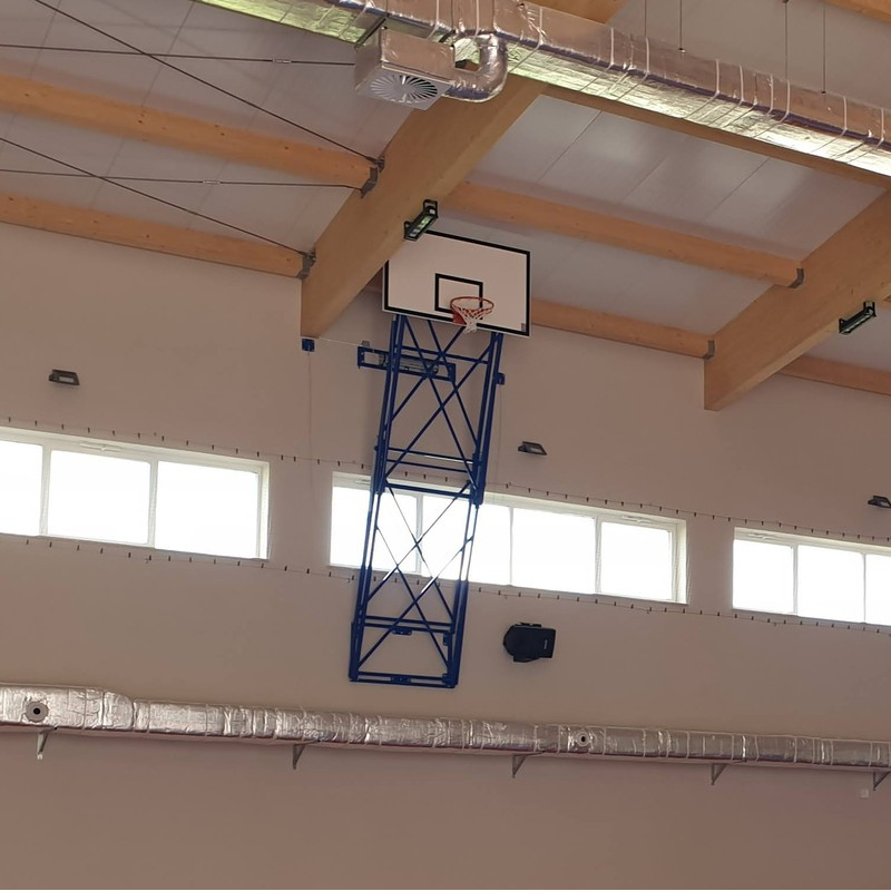 Basketbola konstrukcija, salocīta vertikāli uz augšu